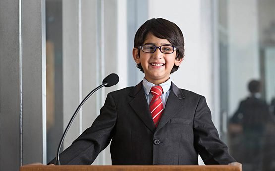 Student practising public speaking at a podium with microphone